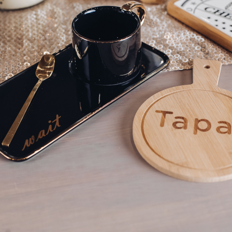 Custom corporate gifts including engraved wood plaques, branded tumblers, and personalized notebooks on a desk.